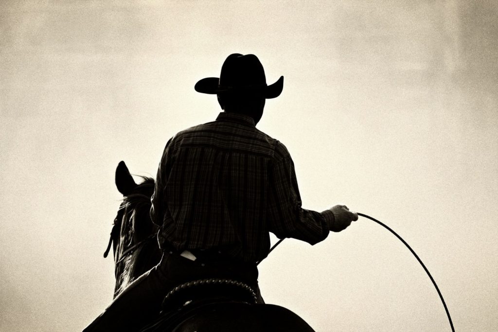 1779908 - cowboy at the rodeo - shot backlit against big cloud of dust, converted with added grain